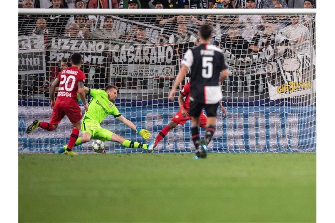 Turins Federico Bernardeschi (r) trifft gegen Leverkusens Torhüter Lukas Hradecky (M). Foto: Marius Becker/dpa