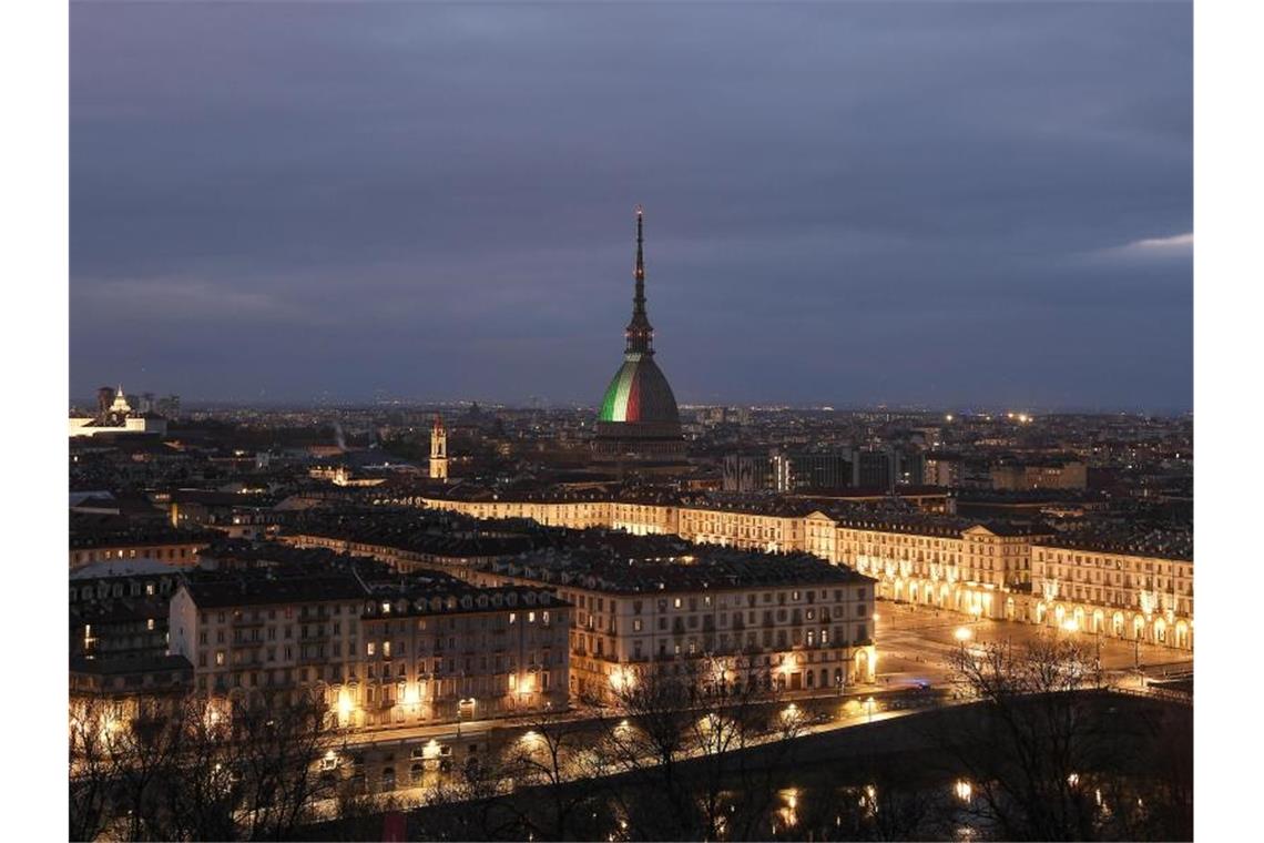 Kampf gegen Corona: Italien verlängert Ausgangsverbote Turins Wahrzeichen, die Mole Antonelliana, wird als ein Zeichen des Respekts für die vielen italienischen Corona-Opfer mit der Trikolore beleuchtet. Foto: Fabio Ferrari/LaPresse via ZUMA Press/dpa