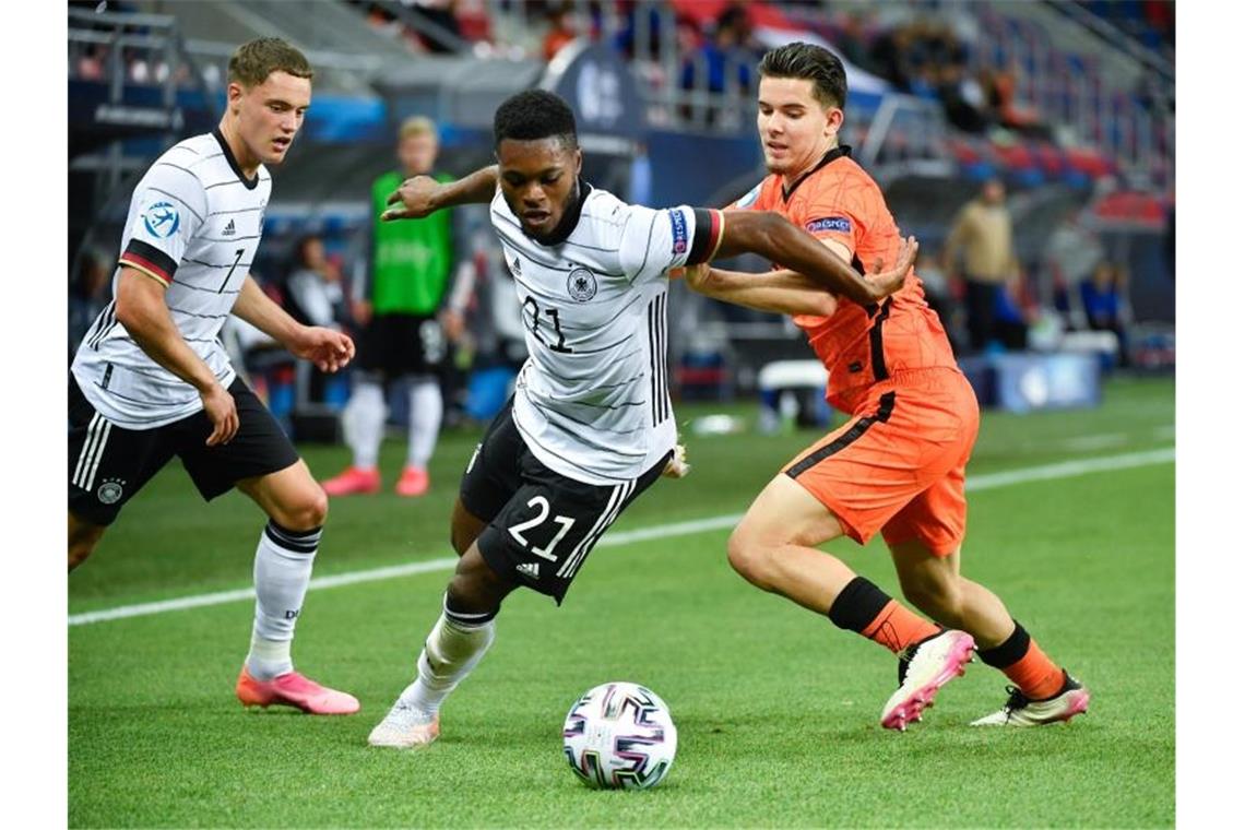 U21-Nationalspieler Ridle Baku (M.) setzt sich im EM-Halbfinale im Zweikampf gegen den Niederländer Ferdi Kadioglu (r) durch. Foto: Marton Monus/dpa