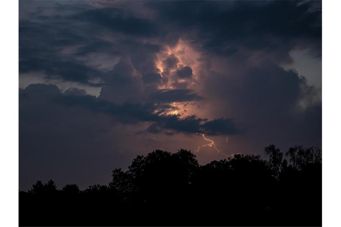 Party-Randale und Gewitter - Deutschland erlebt hitzige Tage Über Berlin blitzt es hinter dunklen Wolken. Foto: Fabian Sommer/dpa