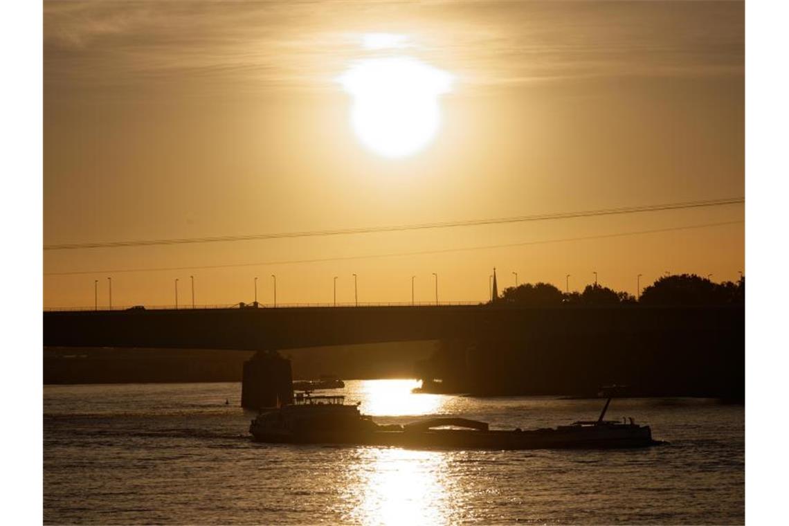 Brütende Hitze in Deutschland - Zum Wochenstart Abkühlung Über dem Rhein bei Köln geht die Sonne auf. Foto: Henning Kaiser/dpa