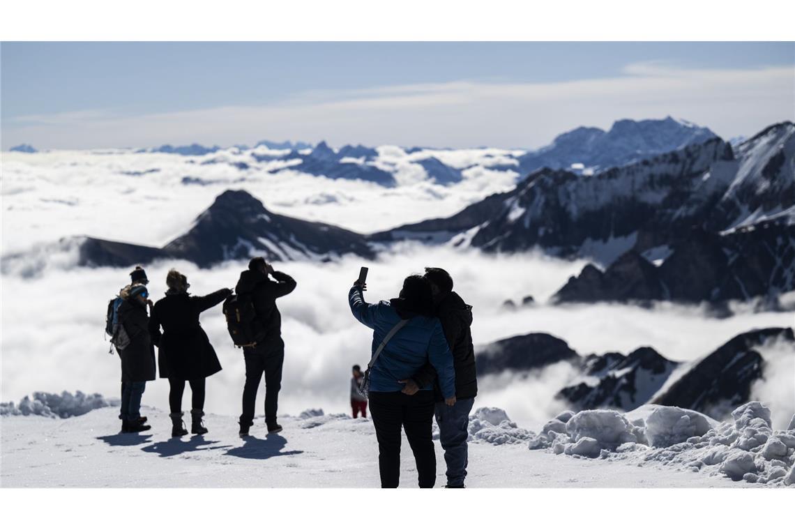 Über den Wolken. Touristen genießen das Wetter auf dem Berg Chäserrugg in der Schweiz. Auf dem Gipfel kann wegen großer Schneemengen über das verlängerte Wochenende Wintersport betrieben werden.