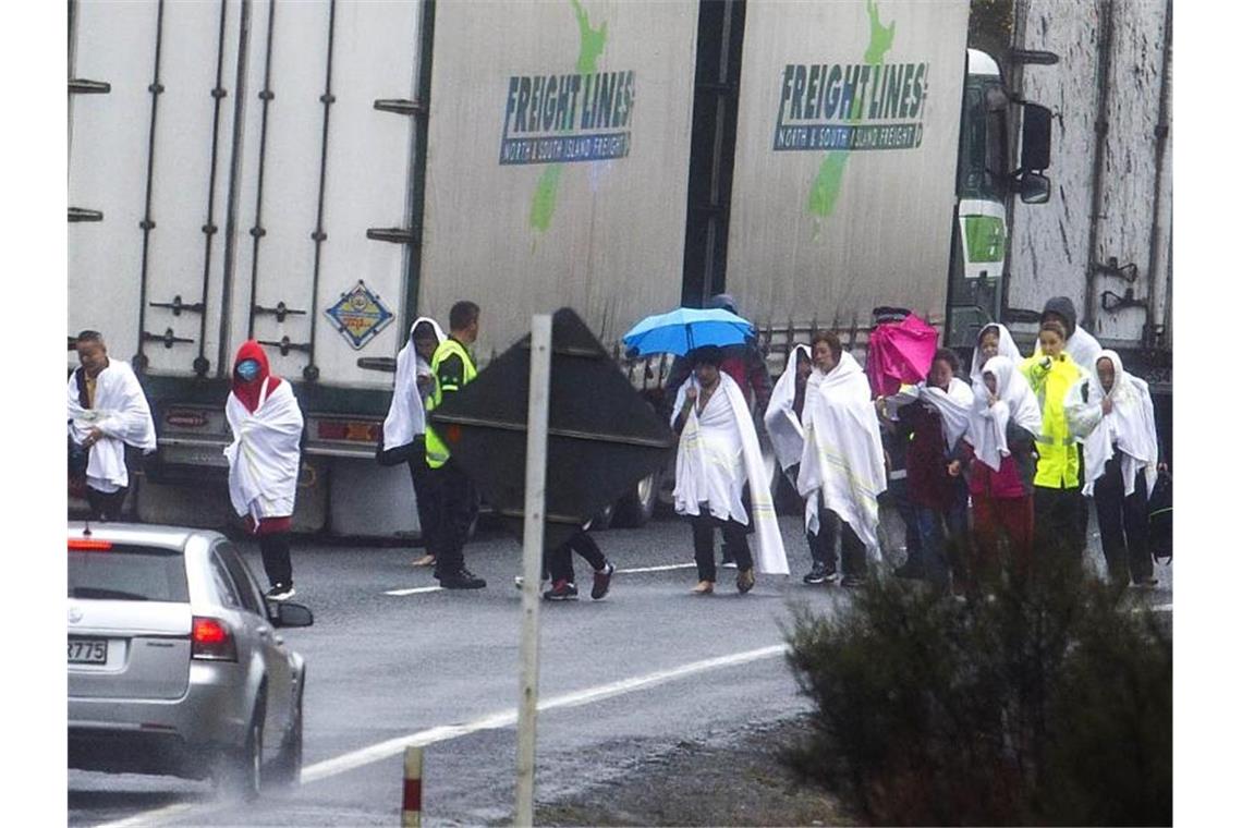 Fünf Touristen bei Busunglück in Neuseeland getötet Überlebende des Busunglücks auf einer Straße unweit des Unfallortes. Foto: Ben Fraser/Rotorua Daily Post via AP