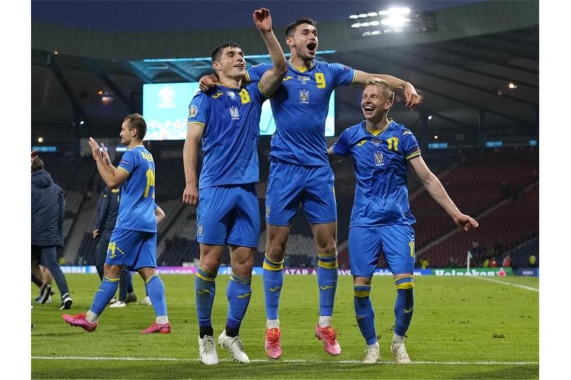 Ukraines Spieler feiern nach dem Spiel den Sieg. Foto: Petr David Josek/Pool AP/dpa