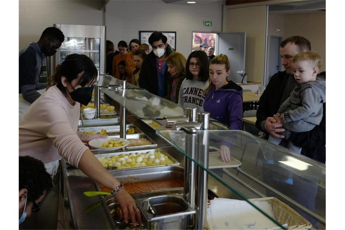 Ukrainische Kriegsflüchtlinge erhalten in der Kantine einer Jugendherberge im französischen Calais ein warmes Mittagessen. Foto: Michel Spingler/AP/dpa