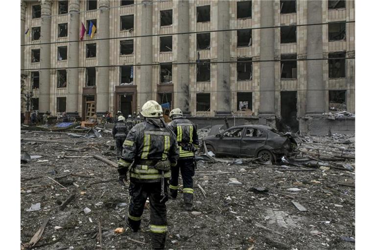 Ukrainische Rettungskräfte arbeiten vor dem beschädigten Rathausgebäude in Charkiw nach dem russischen Beschuss. Foto: Pavel Dorogoy/AP/dpa