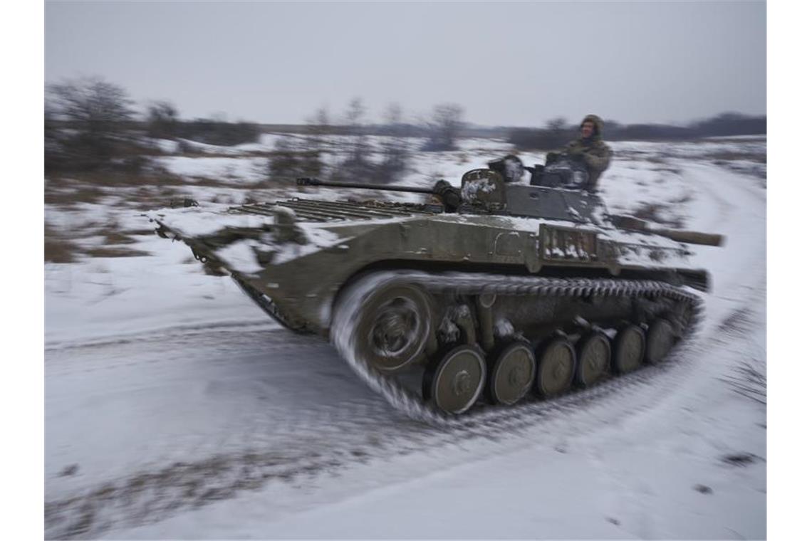 US-Präsident Biden will Truppen nach Osteuropa verlegen Ukrainische Soldaten fahren mit einem gepanzerten Mannschaftstransportwagen durch den Schnee. Foto: Vadim Ghirda/AP/dpa