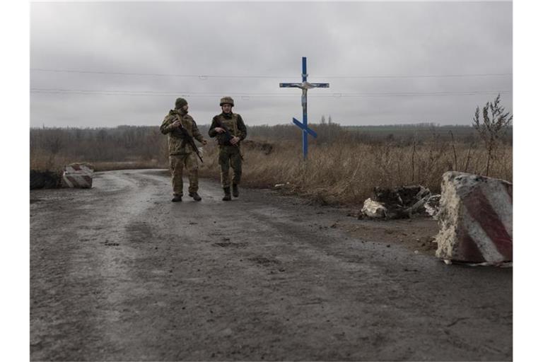 Ukrainische Soldaten gehen an der Trennlinie zu den von Russland unterstützten Rebellen in der Nähe des Dorfes Nevelske in der Ostukraine entlang. Foto: Andriy Dubchak/AP/dpa/Archiv