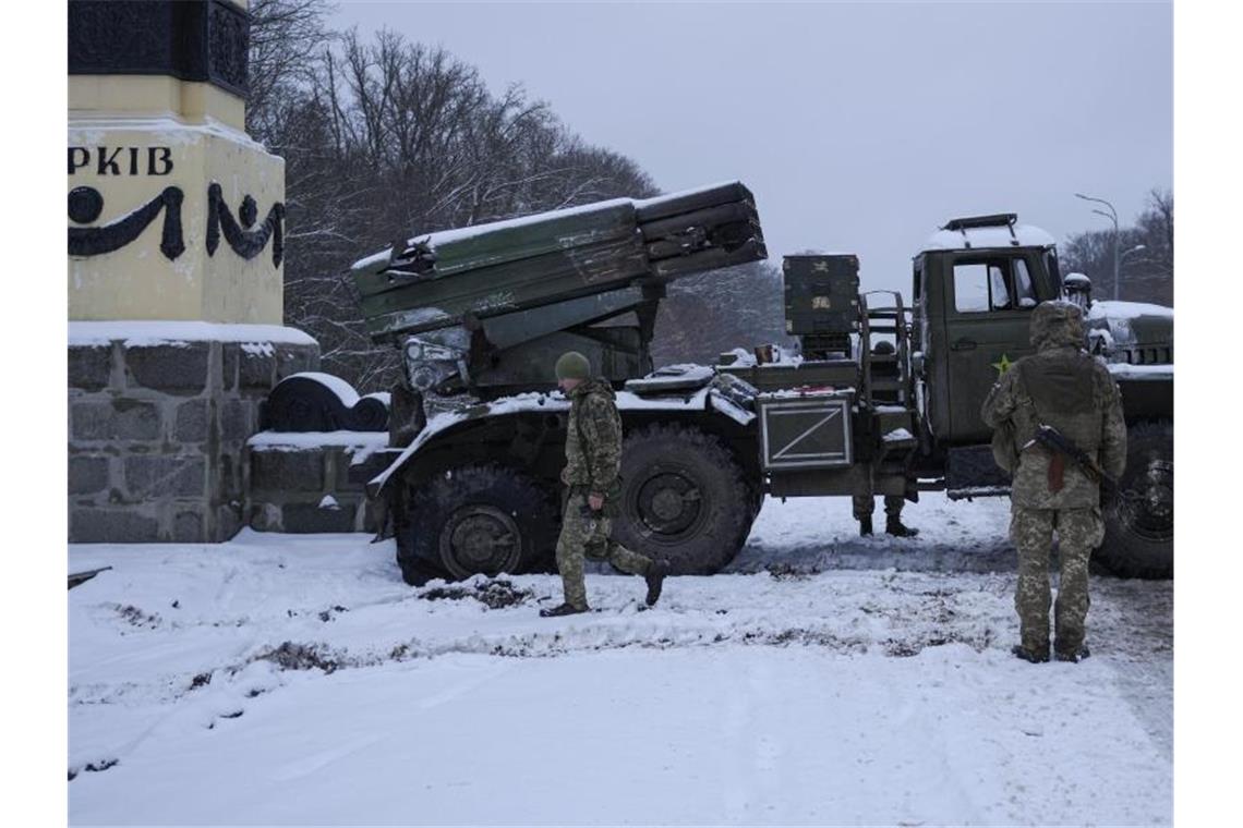Ukrainische Soldaten gehen an einem deaktivierten Mehrfachraketenwerfer des russischen Militärs in Charkiw vorbei. Foto: Vadim Ghirda/AP/dpa