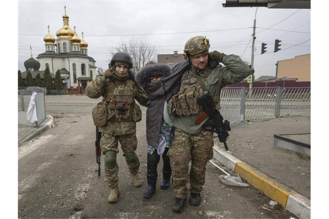 Krieg in der Ukraine: Das ist die Lage am Sonntag Ukrainische Soldaten helfen einer älteren Frau in der Stadt Irpin, Ukraine. Foto: Andriy Dubchak/AP/dpa