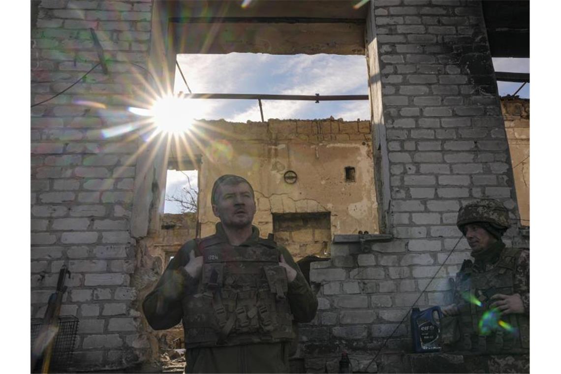Nato befürchtet „vollständigen Angriff“ auf Ukraine Ukrainische Soldaten stehen an einem zerstörten Haus in der Nähe der Grenze zu Russland. Foto: Vadim Ghirda/AP/dpa
