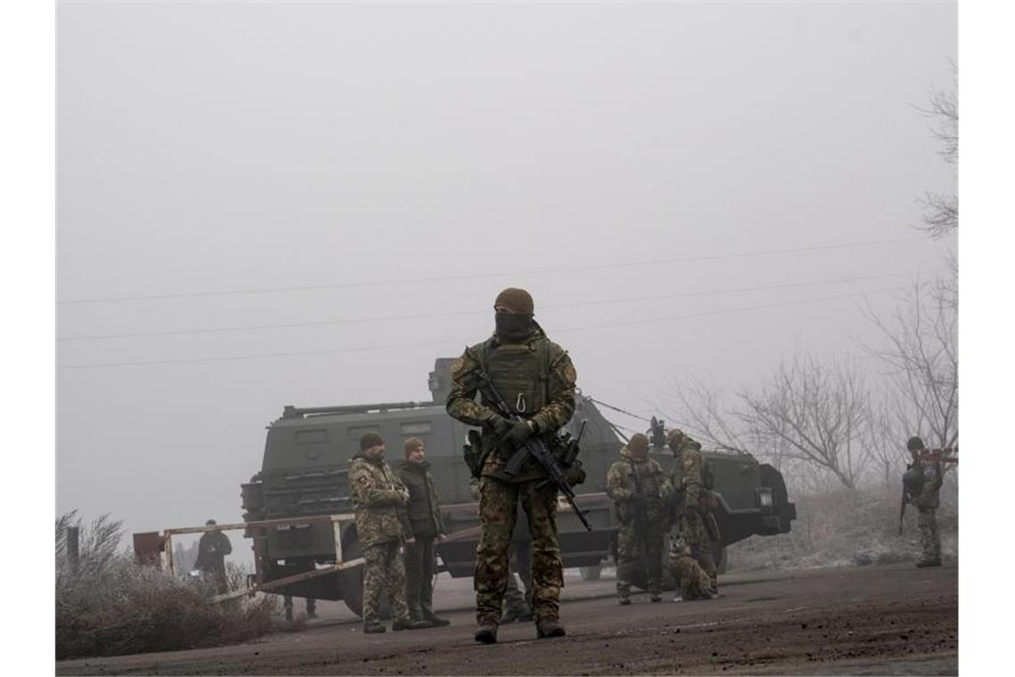 Ukrainische Soldaten stehen Wache. Foto: Evgeniy Maloletka/AP/dpa