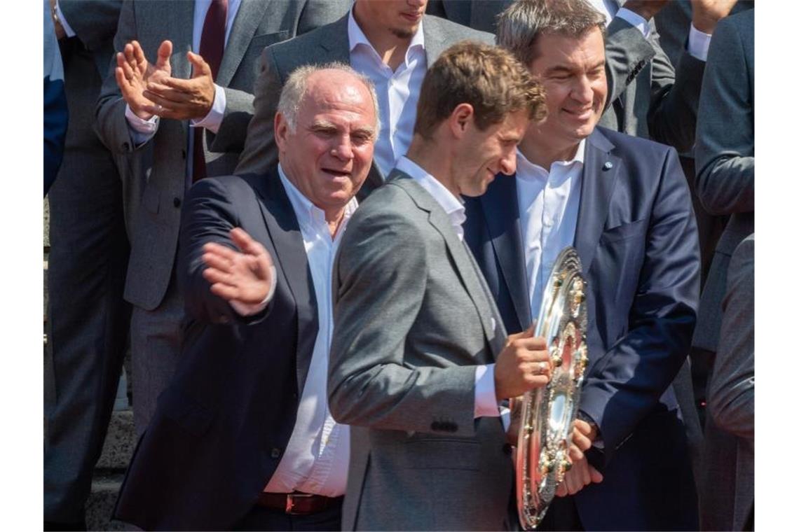 Uli Hoeneß (l) mit Thomas Müller (M) und Ministerpräsident Markus Söder beim Empfang im Hofgarten. Foto: Peter Kneffel