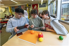 Um die KI zu trainieren, nehmen Klodian Hasani, Lars Pohl und Kjell Much (von links) ungefähr 100 Fotos von jedem Stück Plastikobst auf. Dadurch soll die KI die verschiedenen Obstsorten auch vor unterschiedlich farbigen Hintergründen erkennen. Foto: Dietmar van der Linden