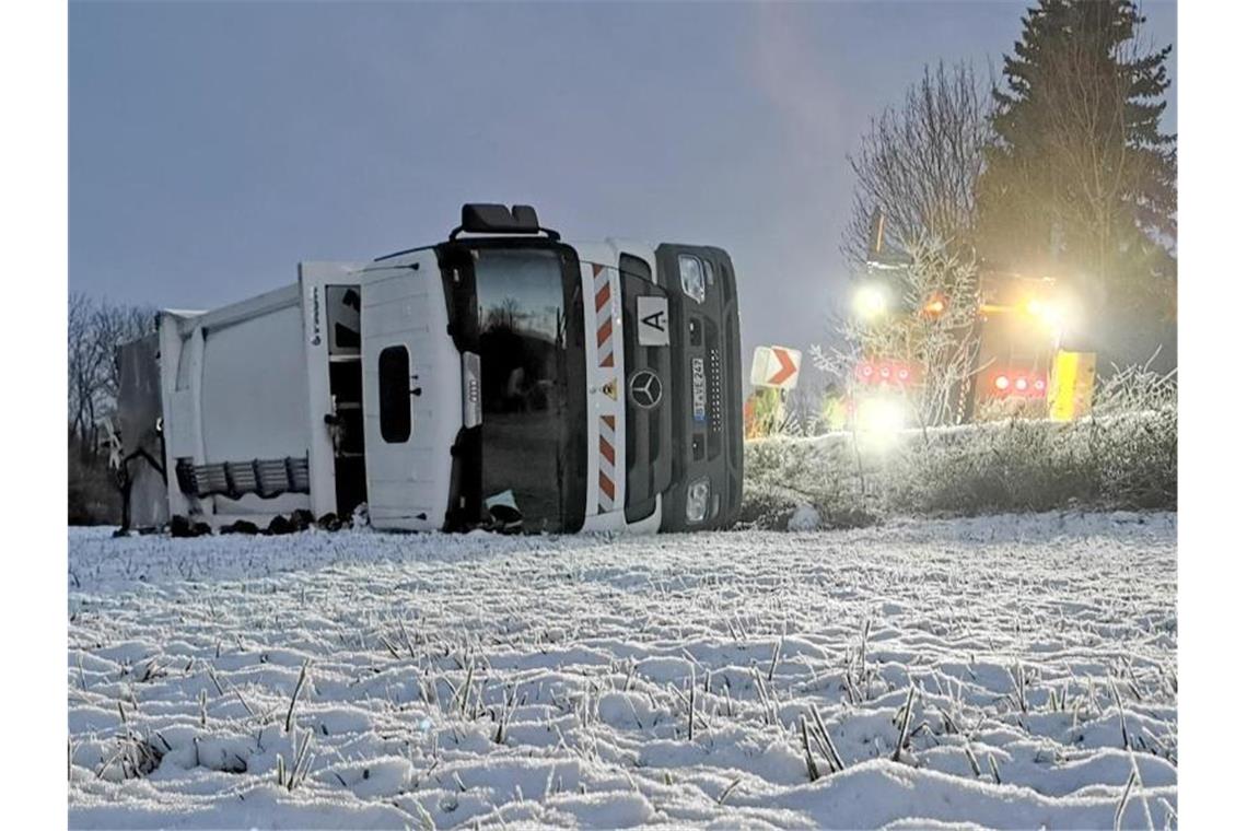 Umgekippter Mülllaster bei Bretzfeld in Baden-Württemberg. Auf eisglatter Fahrbahn war der Lastwagen zuvor von der Straße gerutscht. Foto: Julian Buchner/dpa