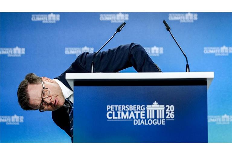 Umweltminister Carsten Schneider (SPD) beugt sich beim 17. Petersberger Klimadialog neben das Pult.