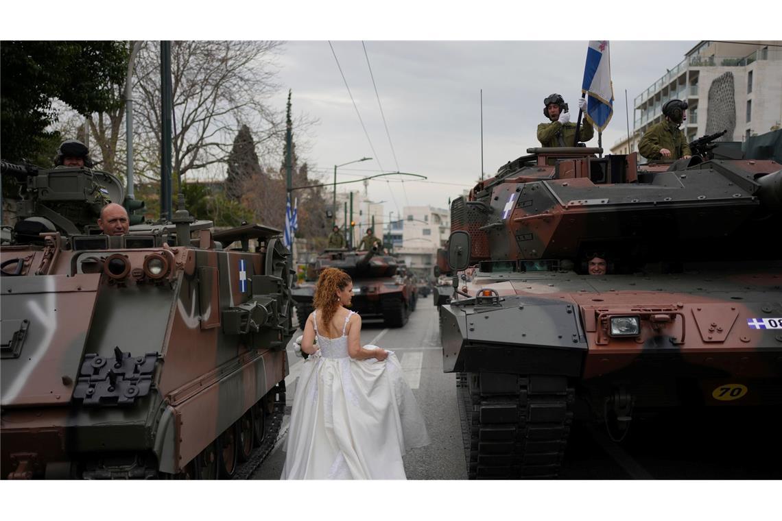 Bilder des Tages Unabhängigkeitstag in Griechenland: Ein als Braut gekleidetes Model geht zwischen Panzern während eines Fotoshootings vor einer Militärparade zum Gedenken an den Beginn des griechischen Unabhängigkeitskrieges von 1821 gegen die 400-jährige osmanische Herrschaft vorbei.
