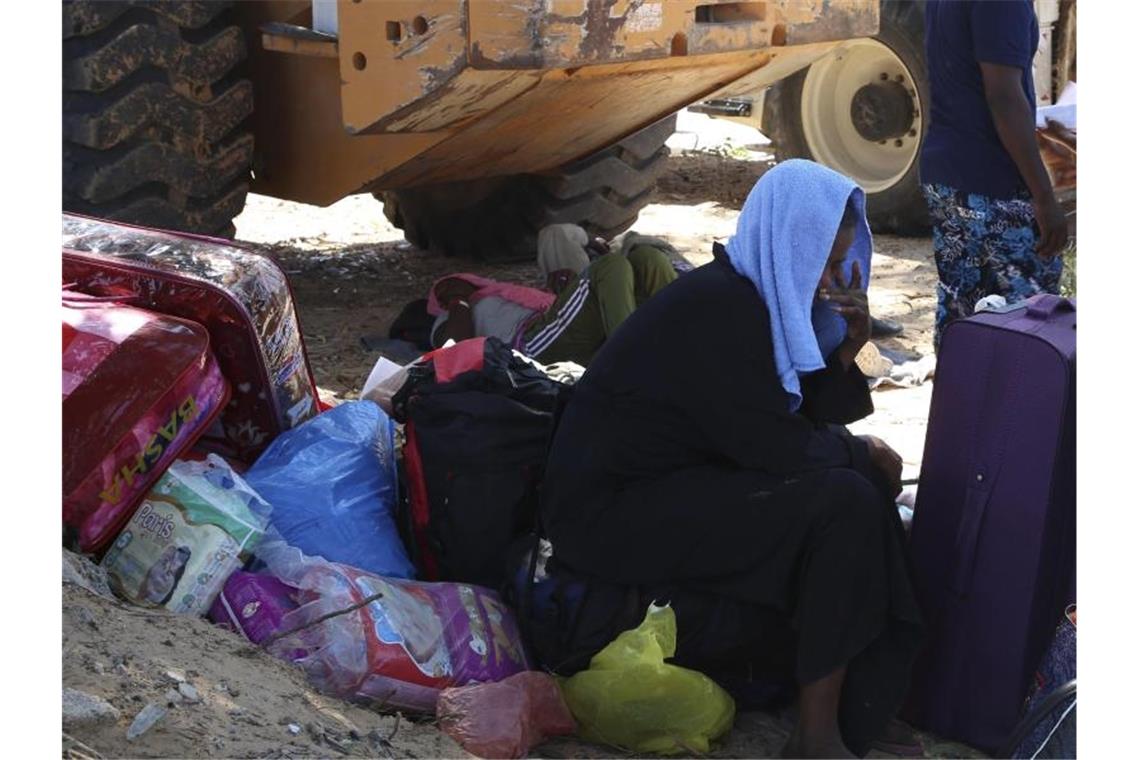 Und nun? Ein Migrant sitzt mit seinen wenigen Habseligkeiten inmitten der Trümmer des zerstörten Internierungslagers. Foto: Hazem Ahmed/AP
