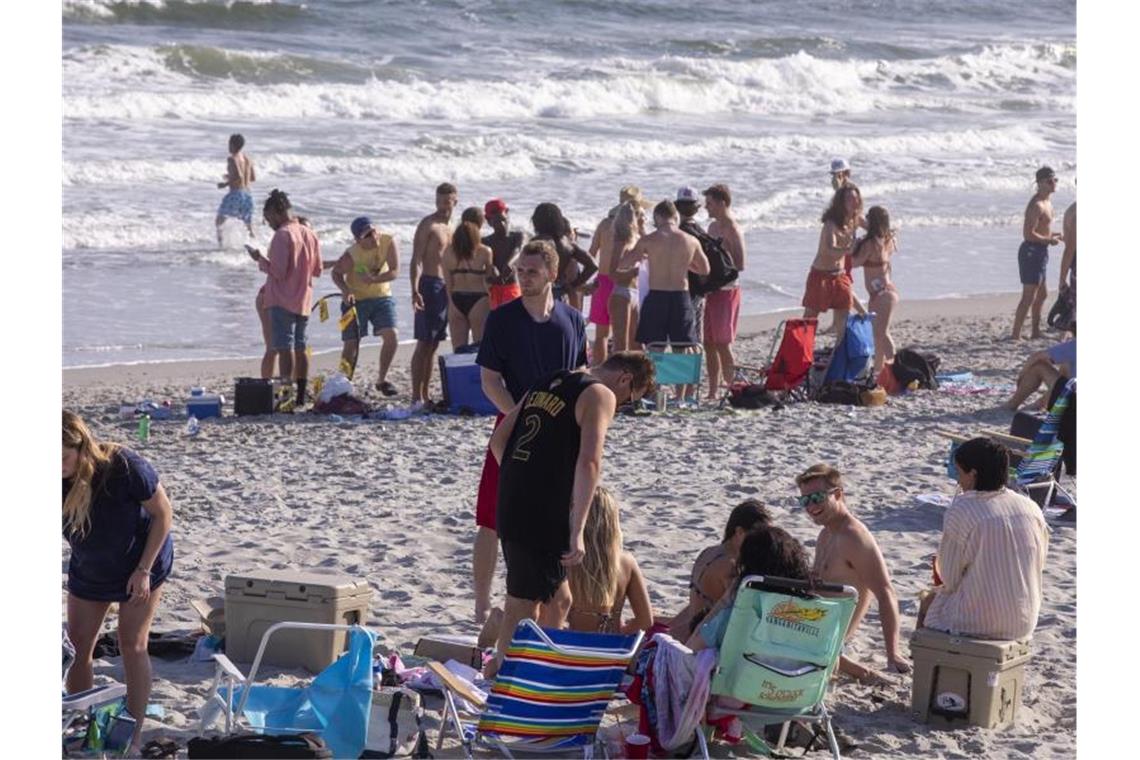 Ungeachtet der Ansteckungsgefahr durch das neuartige Coronavirus vergnügen sich Dutzende Studenten an einem Strand an der US-Ostküste. Foto: Jason Lee/The Sun News/AP/dpa