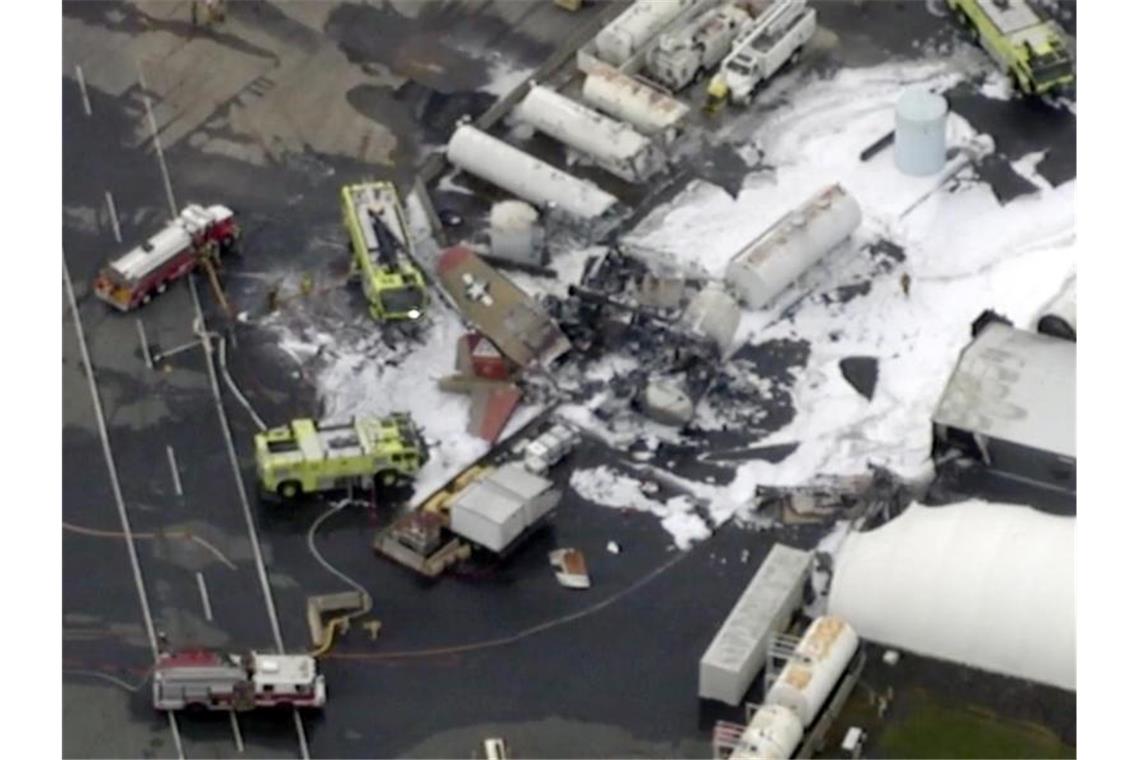 Mindestens sieben Tote nach Absturz von Weltkriegsbomber Unglücksort: Vom Wrack der B-17 stieg Rauch auf, die Feuerwehr war mit schwerem Löschgerät im Einsatz. Foto: Uncredited/WFXT Boston 25 News/AP/dpa