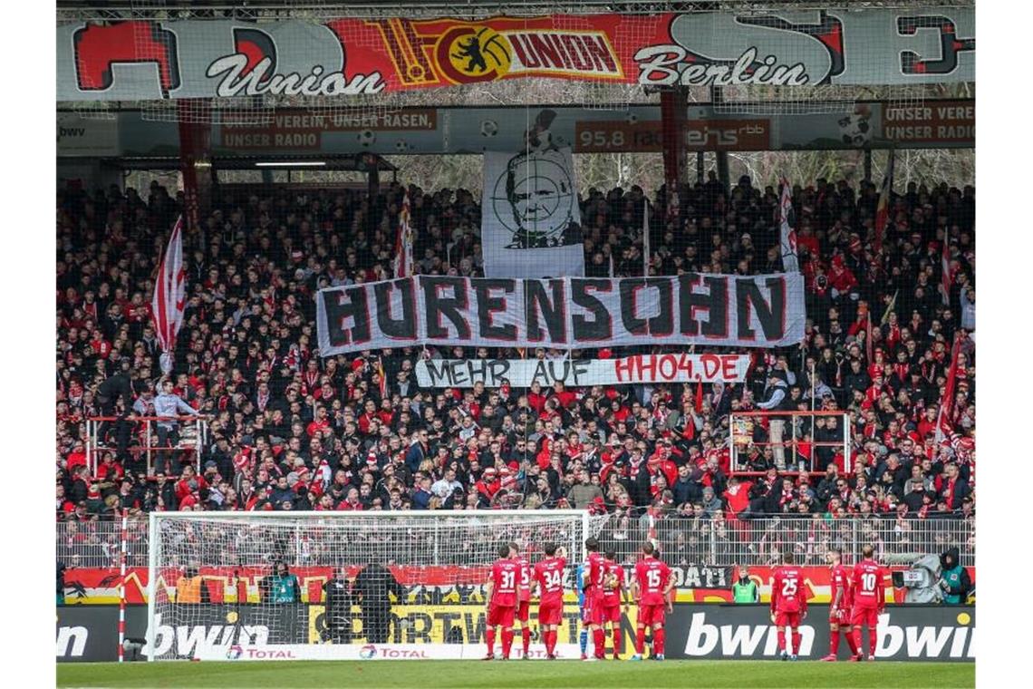 Hopp im Fadenkreuz: Partie Union-Wolfsburg unterbrochen Unions Fans auf der Waldseite zeigen ein Banner mit dem Abbild von Dietmar Hopp im Fadenkreuz. Foto: Andreas Gora/dpa