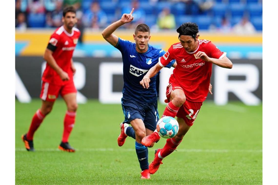 Unions Genki Haraguchi (r) im Laufduell mit dem Hoffenheimer Andrej Kramaric. Foto: Uwe Anspach/dpa