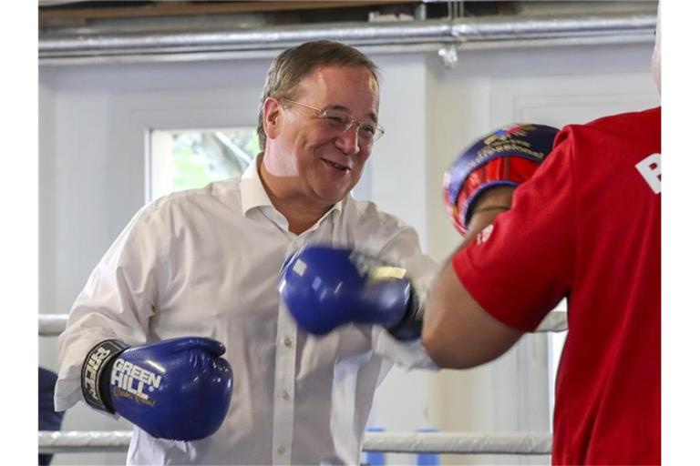 Unions-Kanzlerkandidat Armin Laschet ist bei seinem Wahlkampfauftakt mit einem Trainer des Boxcamps Gallus, in dem Kinder und Jugendliche trainieren, in den Ring gestiegen. Foto: Armando Babani/AFP-Pool/dpa