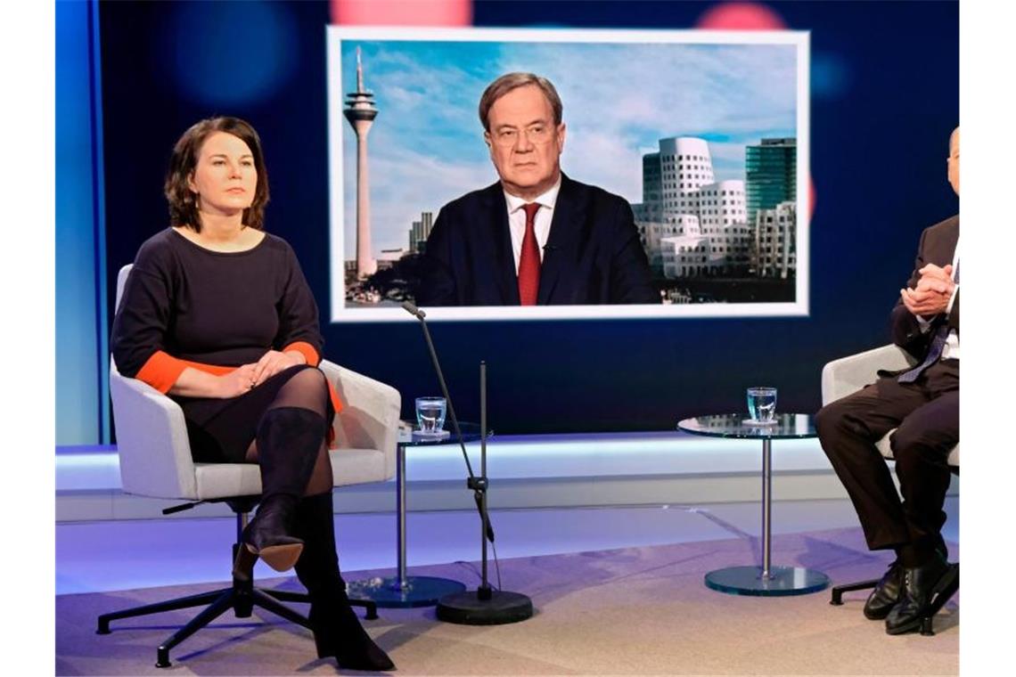 Erster Schlagabtausch von Baerbock, Laschet und Scholz Unions-Kanzlerkandidat Armin Laschet wird auf einem Fernsehschirm gezeigt, während die Mitbewerbern von Grünen und SPD, Annalena Baerbock und Olaf Scholz im Fernsehstudio bei einer Diskussionsrunde des WDR-Europaforums in Berlin sitzen. Foto: Oliver Ziebe/WDR/dpa