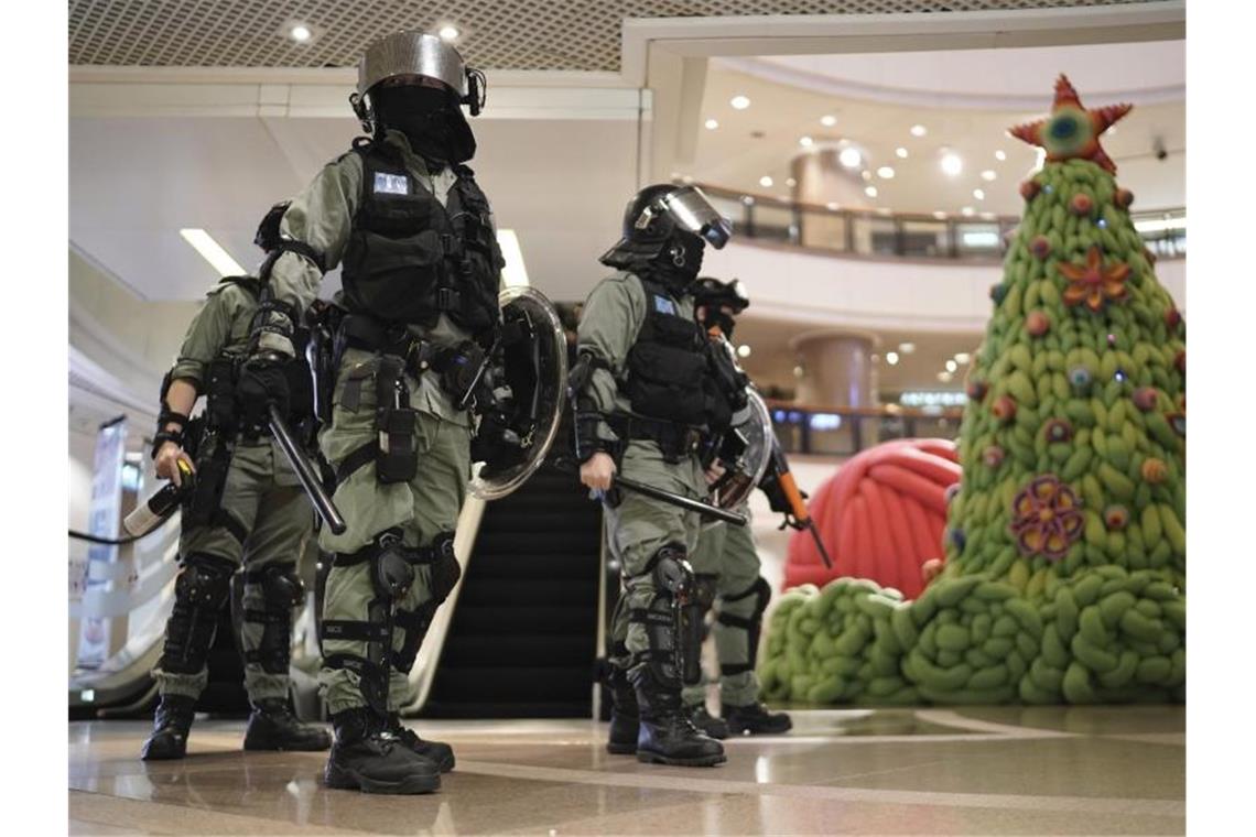 Chaos und Zusammenstöße überschatten Weihnachten in Hongkong Unruhiger Heiligabend: Polizisten schützen ein Einkaufszentrum. Foto: Kin Cheung/AP/dpa