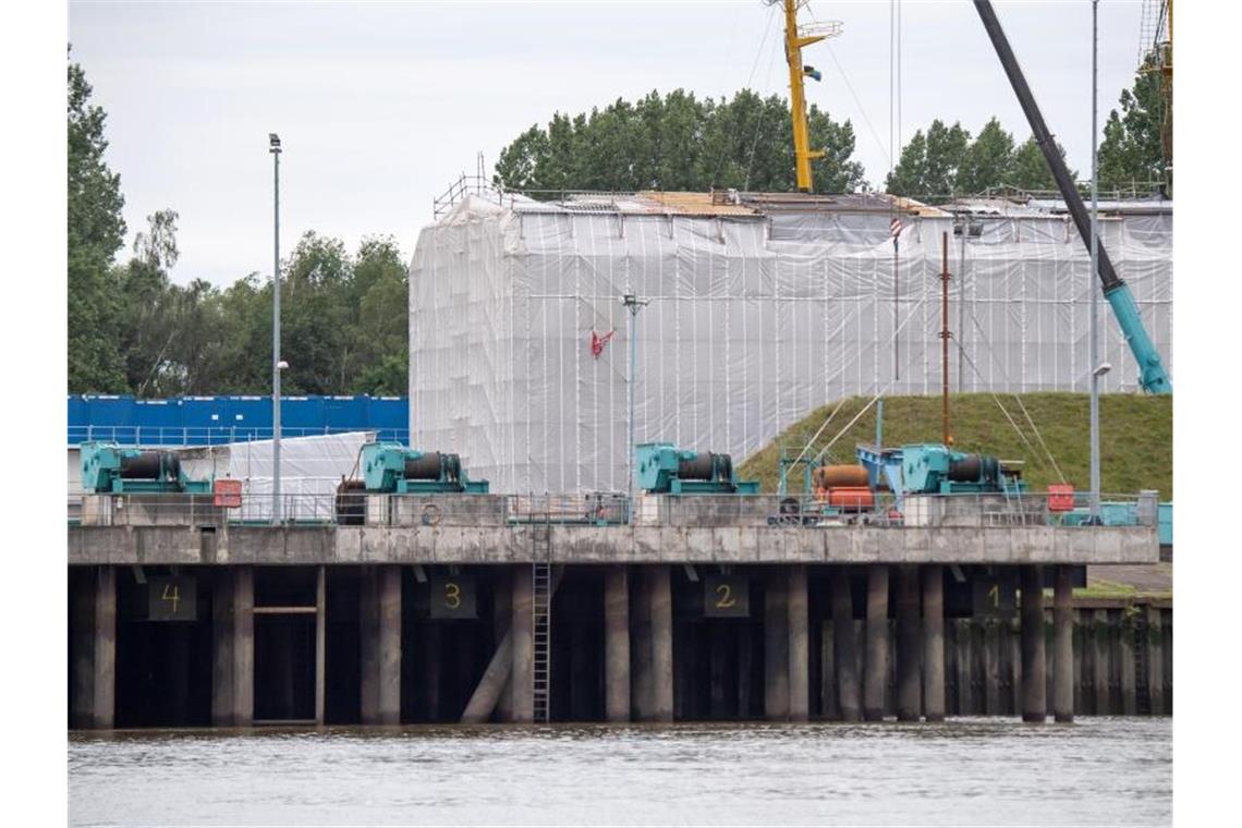 Unter Planen liegt das Segelschulschiff „Gorch Fock“ in der Lürssen-Werft in Niedersachsen. Die Generalüberholung des Marinesegelschiffs war lange ein finanzielles und politisches Desaster. Foto: Sina Schuldt/dpa