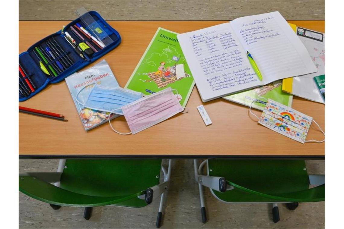 Unterrichtsmaterialien und Masken liegen während einer Pause auf einem Tisch in einer Grundschule. Foto: Patrick Pleul/dpa-Zentralbild/ZB/Archivbild