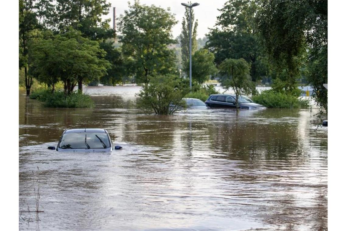 Unwetter mit Starkregen hat vielerorts die die Flüsse anschwellen und über ihre Ufer treten lassen. So wie hier in Neustadt An Der Aisch. Foto: Daniel Karmann/dpa