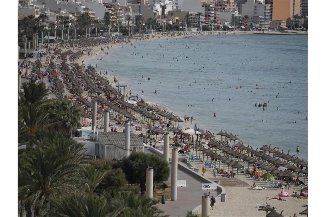 Urlauber entspannen am Strand von Arenal auf Mallorca. Foto: Clara Margais/dpa