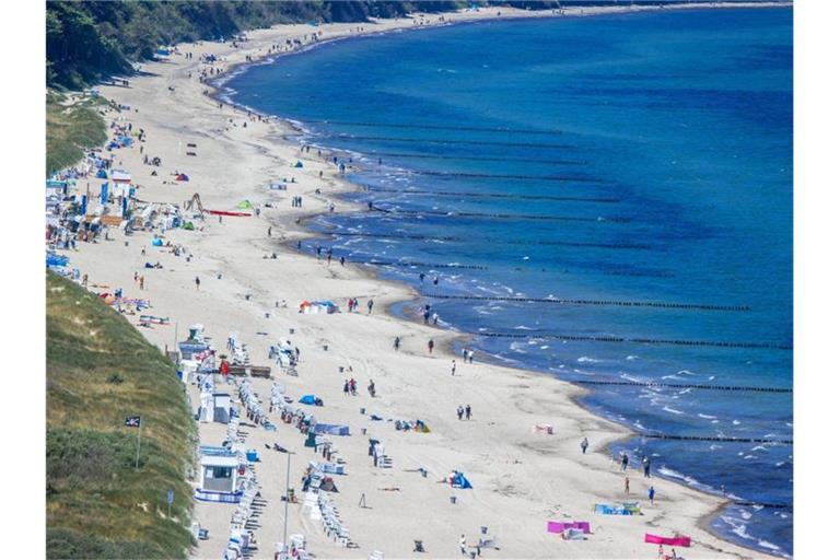 Urlauber genießen das Sonnenwetter am Ostseestrand. Foto: Jens Büttner/dpa-Zentralbild/dpa