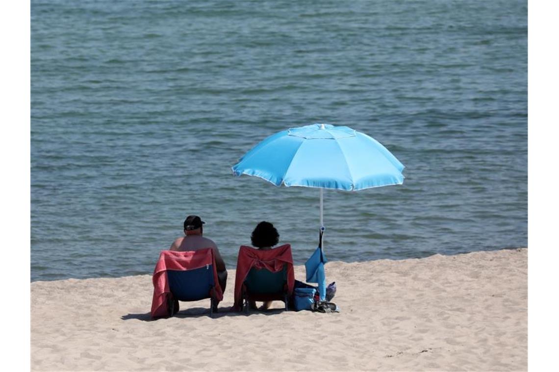 Urlauber genießen das warme Sommerwetter. Foto: Bernd Wüstneck/dpa