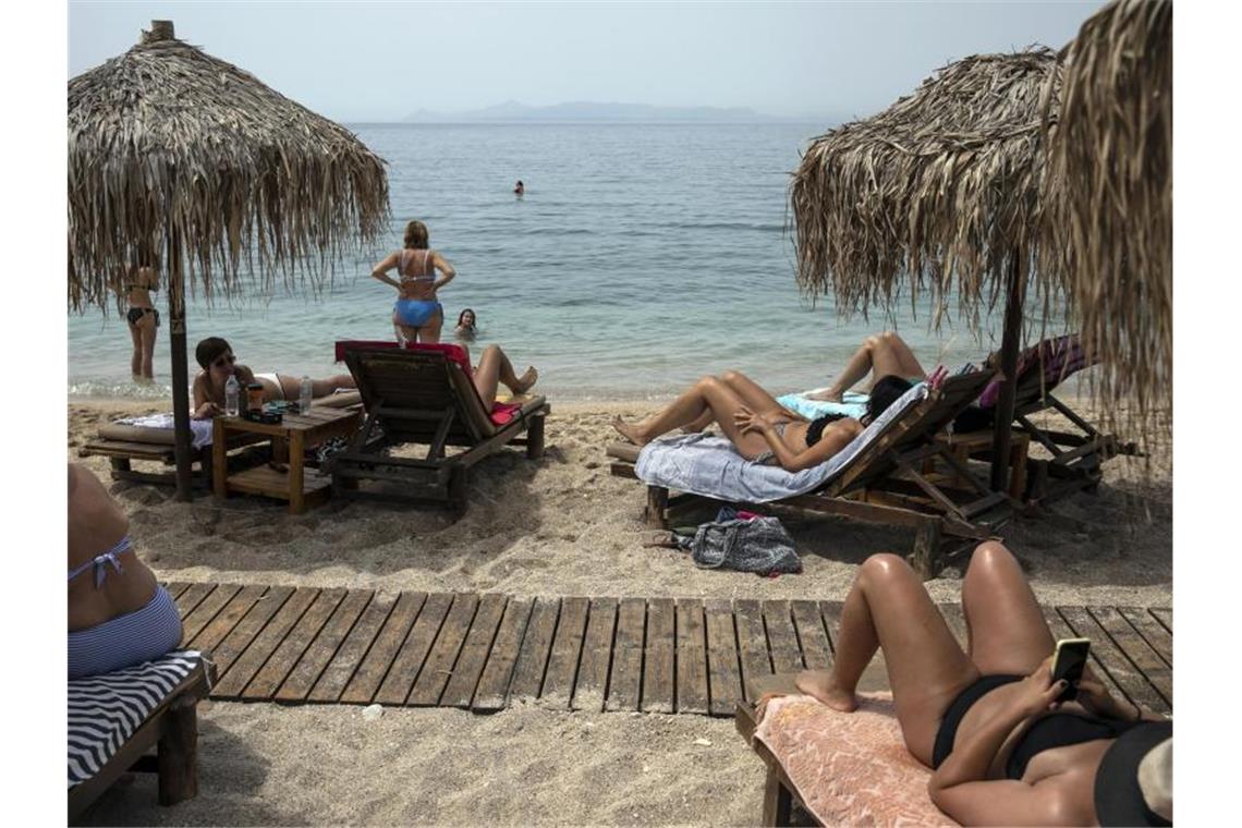 Urlauber liegen am Strand von Alimos (Griechenland). Foto: Yorgos Karahalis/AP/dpa