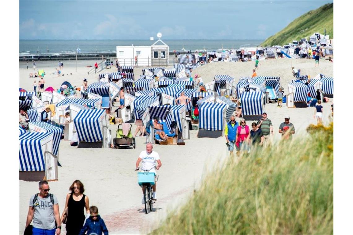 Urlaubsgäste sitzen bei sonnigem Wetter in ihren Strandkörben am Nordstrand der Insel Norderney. Foto: Hauke-Christian Dittrich/dpa