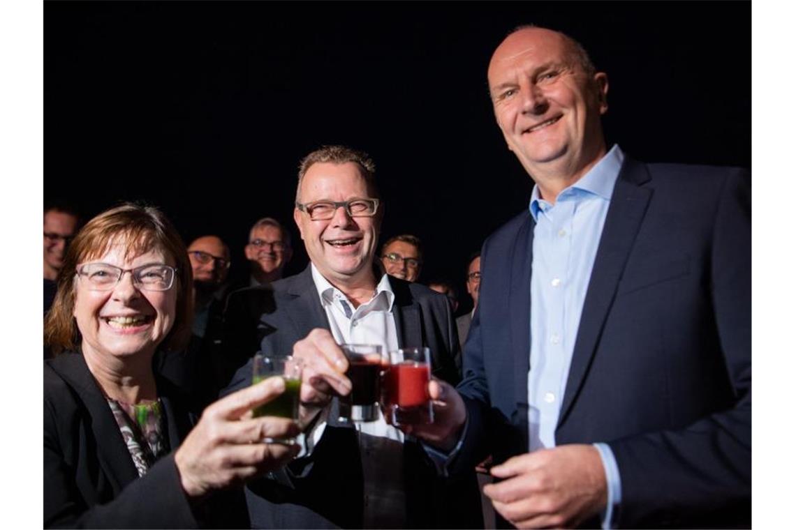 Ursula Nonnemacher von den Grünen (l), Michael Stübgen von der CDU (M) und Ministerpräsident Dietmar Woidke (SPD, r) stoßen auf ihre künftige Koalition an. Foto: Monika Skolimowska/dpa-Zentralbild/dpa