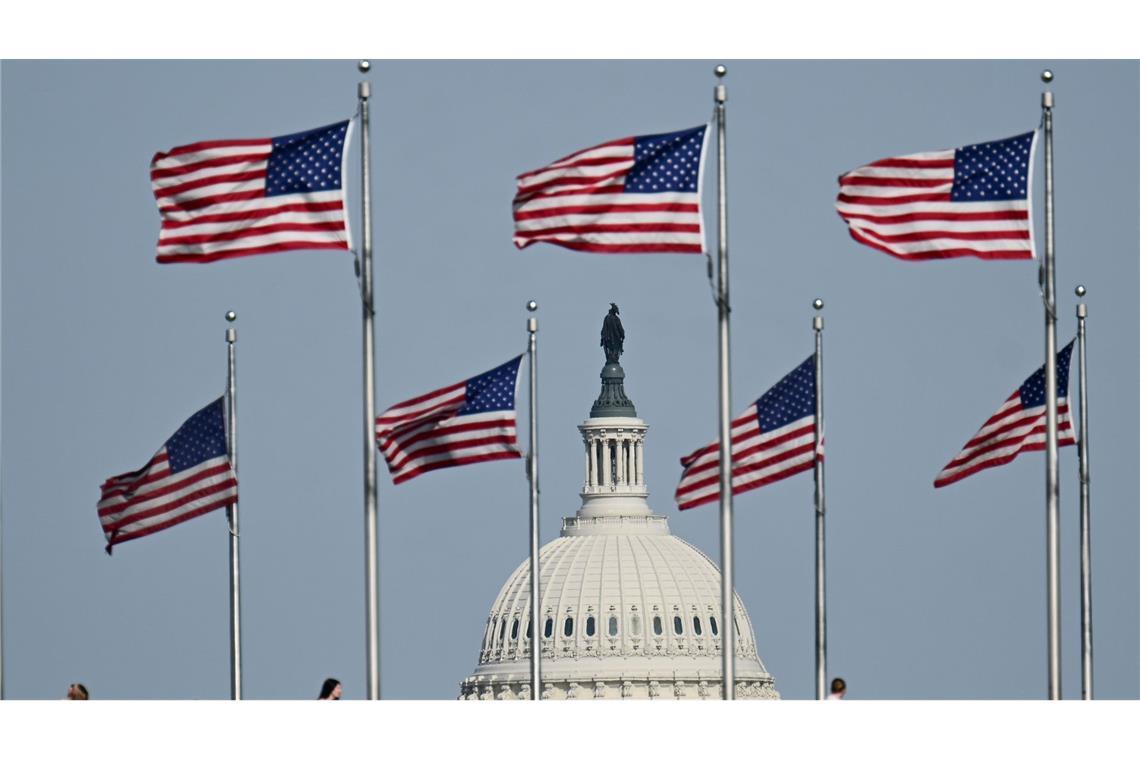 US-Fahnen wegen am Washington Monument. Im Hintergrund ist die Kuppel des US-Kapitols zu sehen.