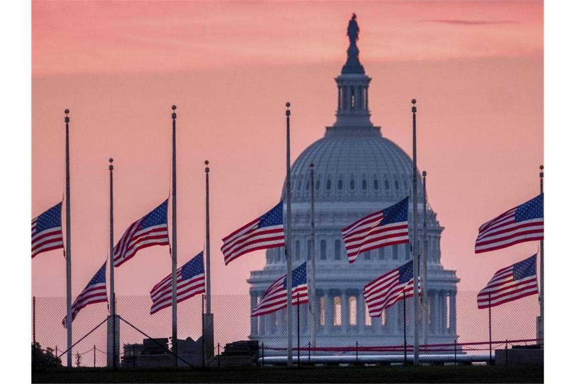 US-Flaggen wehen vor dem Kapitol in Washington auf halbmast. Foto: J. David Ake/AP/dpa