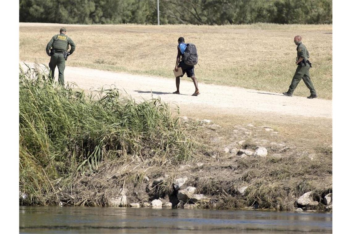 Nach Abschiebung öffnen USA Grenzübergang in Del Rio wieder US-Grenzschutzbeamte sprechen mit einem haitianischen Migranten, der von Ciudad Acuna, Mexiko, in die USA eingereist ist. Foto: Nick Wagner/XinHua/dpa