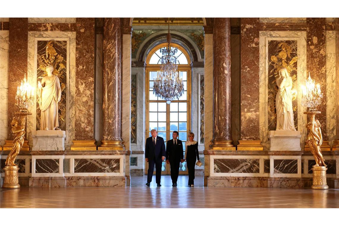 US-Präsident Donald Trump (l) wird vor einem gemeinsamen Abendessen vom französischen Präsidenten Emmanuel Macron und dessen Ehefrau Brigitte Macron durch das Schloss Versailles geführt.