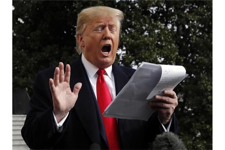 US-Präsident Donald Trump liest von seinen handschriftlich verfassten Notizen ab, als er mit Journalisten vor dem Weißen Haus spricht. Trump äußerte sich zu den Impeachment-Ermittlungen. Foto: Jacquelyn Martin/AP/dpa