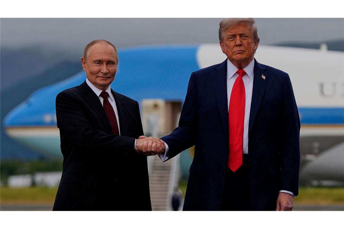 US-Präsident Donald Trump (r) und der russische Präsident Wladimir Putin geben sich auf dem Militärstützpunkt Joint Base Elmendorf-Richardson (in Alaska) die Hand.