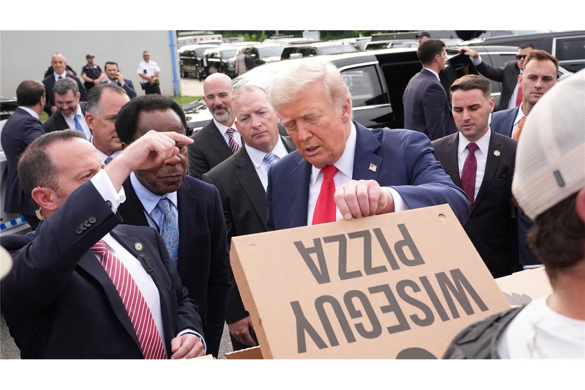 US-Präsident Donald Trump schaut sich eine Pizza an, während er sich mit Mitgliedern von Strafverfolgungsbehörden und Soldaten der Nationalgarde in Washington trifft.