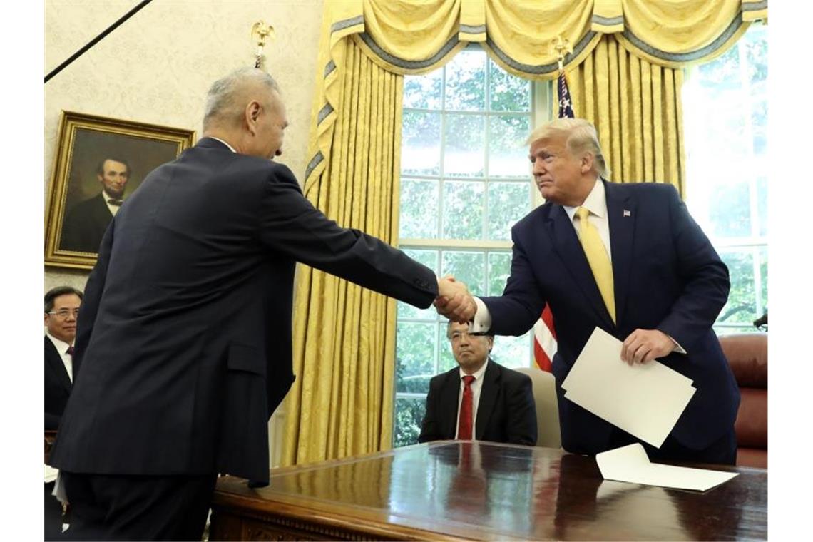 USA verkünden Einigung auf Handels-Teilabkommen mit China US-Präsident Donald Trump und der chinesische Vizepremier Liu He (l) reichen sich im Oval Office im Weißen Haus die Hand. Foto: Andrew Harnik/AP/dpa