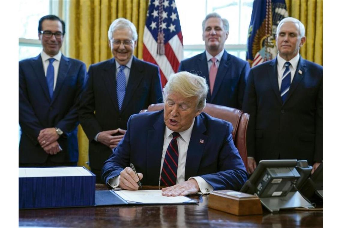 US-Präsident Donald Trump unterzeichnet das Coronavirus-Konjunkturpaket. Foto: Evan Vucci/AP/dpa