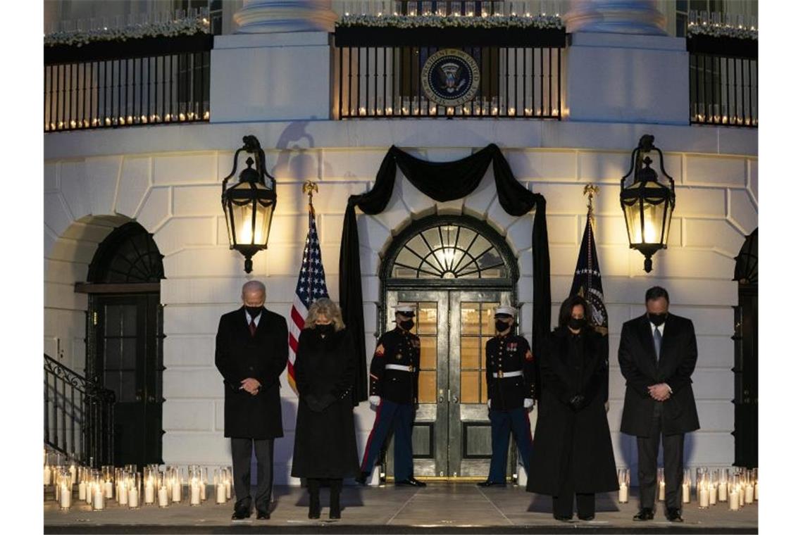 US-Präsident Joe Biden (l-r), Jill Biden, Vizepräsidentin Kamala Harris und ihr Mann Douglas Emhoff gedenken mit einer Schweigeminute vor dem Weißen Haus der Opfer der Pandemie. Foto: Evan Vucci/AP/dpa