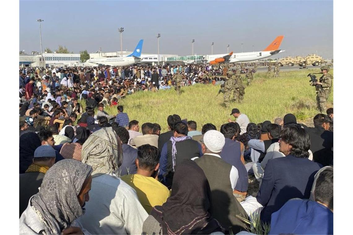 Evakuierung aus Kabul läuft - Luftbrücke geplant US-Soldaten bewachen eine Absperrung am internationalen Flughafen in Kabul. Foto: -/AP/dpa