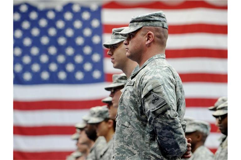 US-Soldaten stehen vor einer US-Flagge. Foto: Frank May/dpa/Archivbild